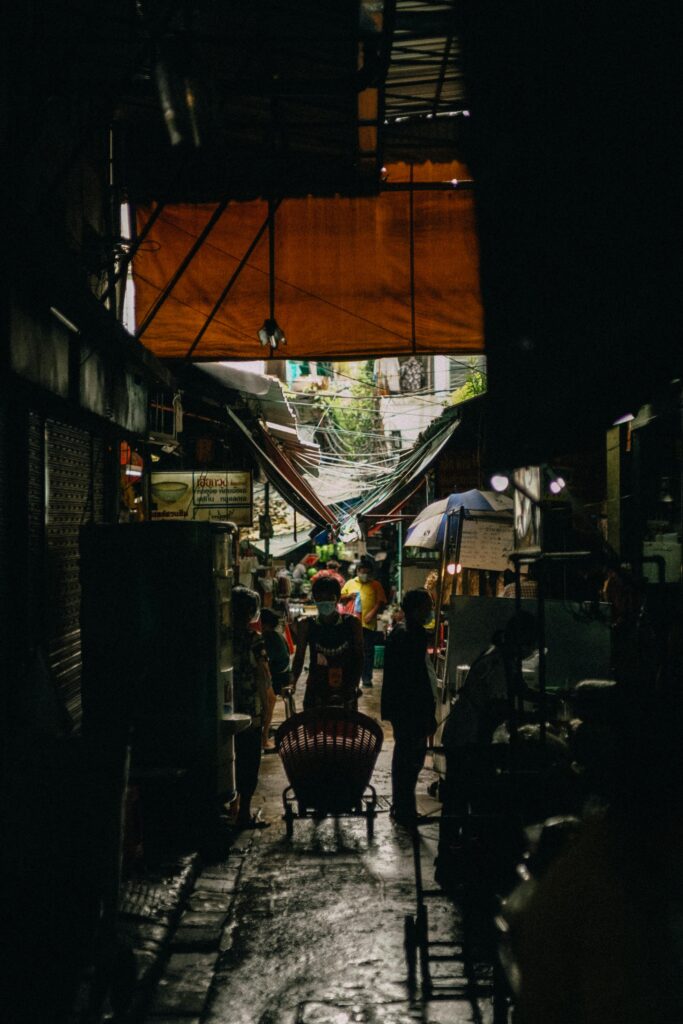 A vibrant market alleyway filled with people and stalls, captured in an urban setting.